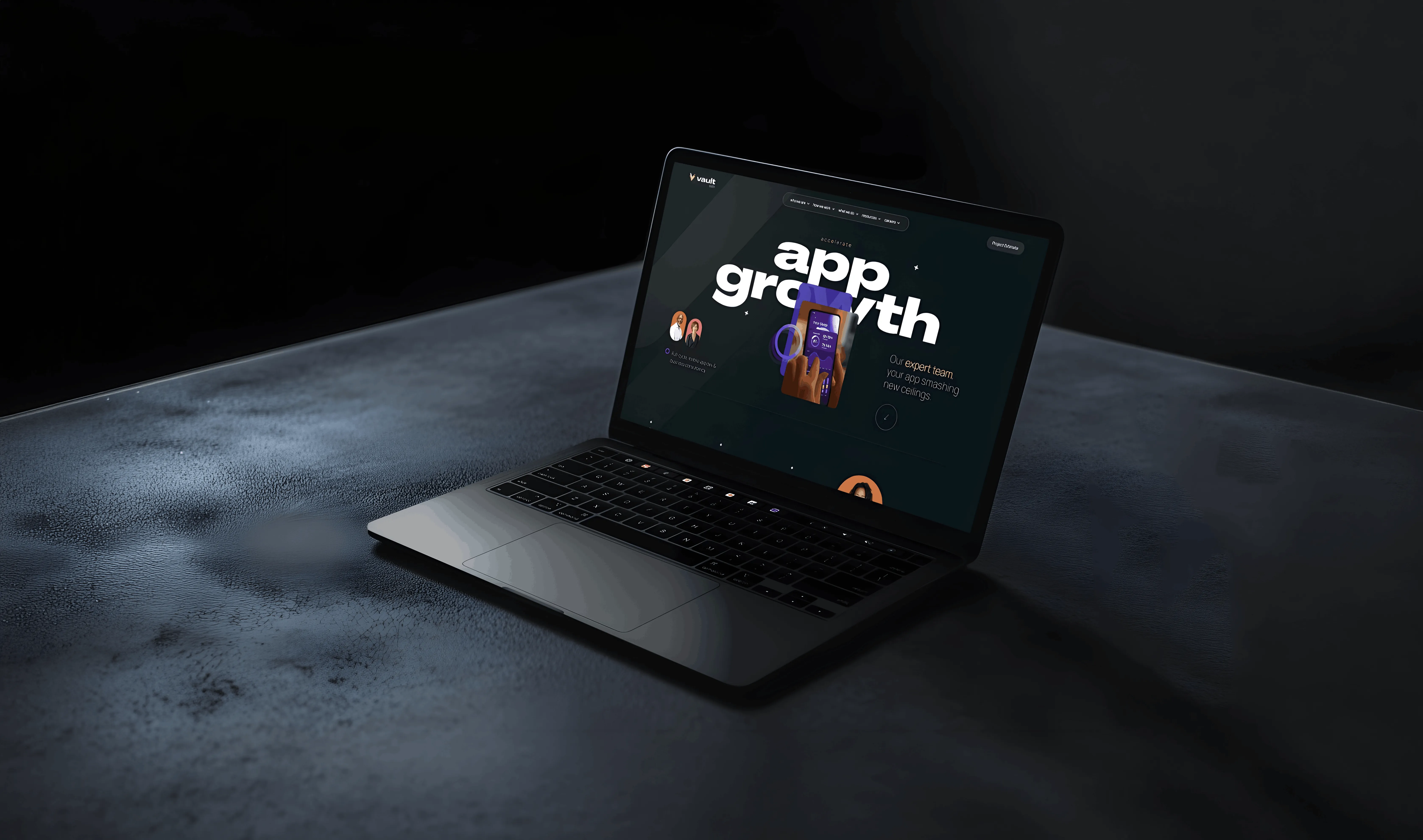Laptop on dark textured surface displaying a webpage with the text app growth and a hand holding a smartphone.